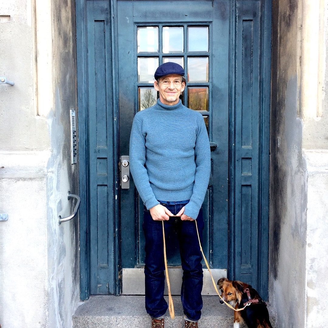 Portrait of Magnus Joergensen standing with his dog in a doorway